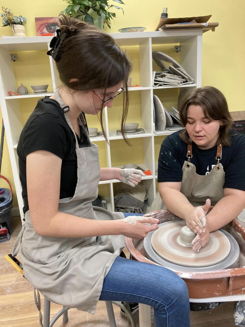 Instructor helping guest learn the pottery wheel