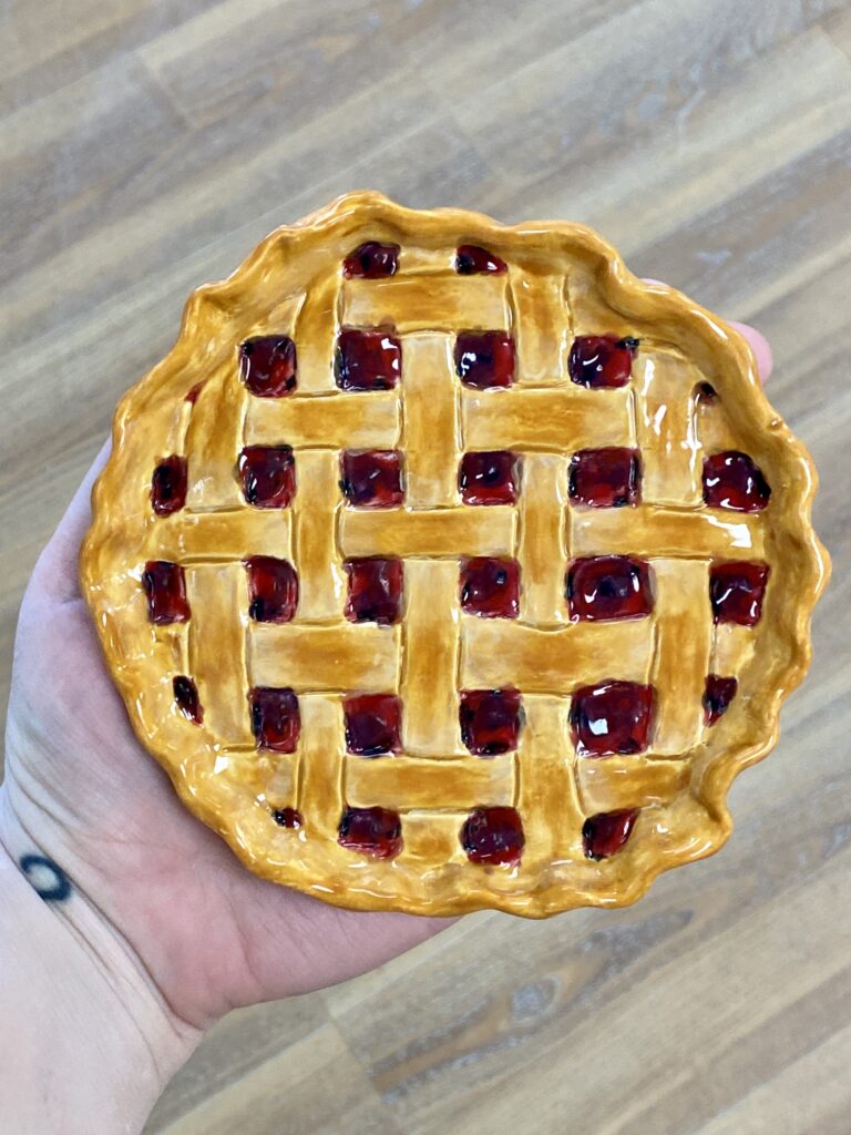 Ceramic plate made to look like the top of a berry pie with lattice crust.