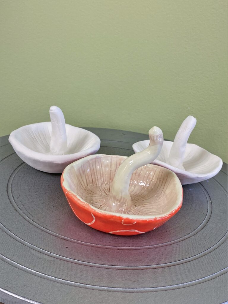 2 bisque, unpainting, and 1 glazed red and tan mushroom ring holders -- looks like a mushroom upside down