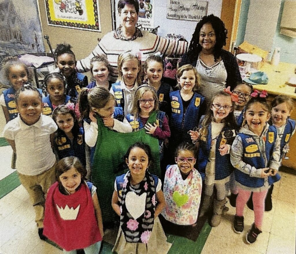 kids with capes in a classroom smiling