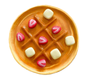 ceramic tic tac toe board that looks like a waffle with strawberries and butter pats as the game pieces